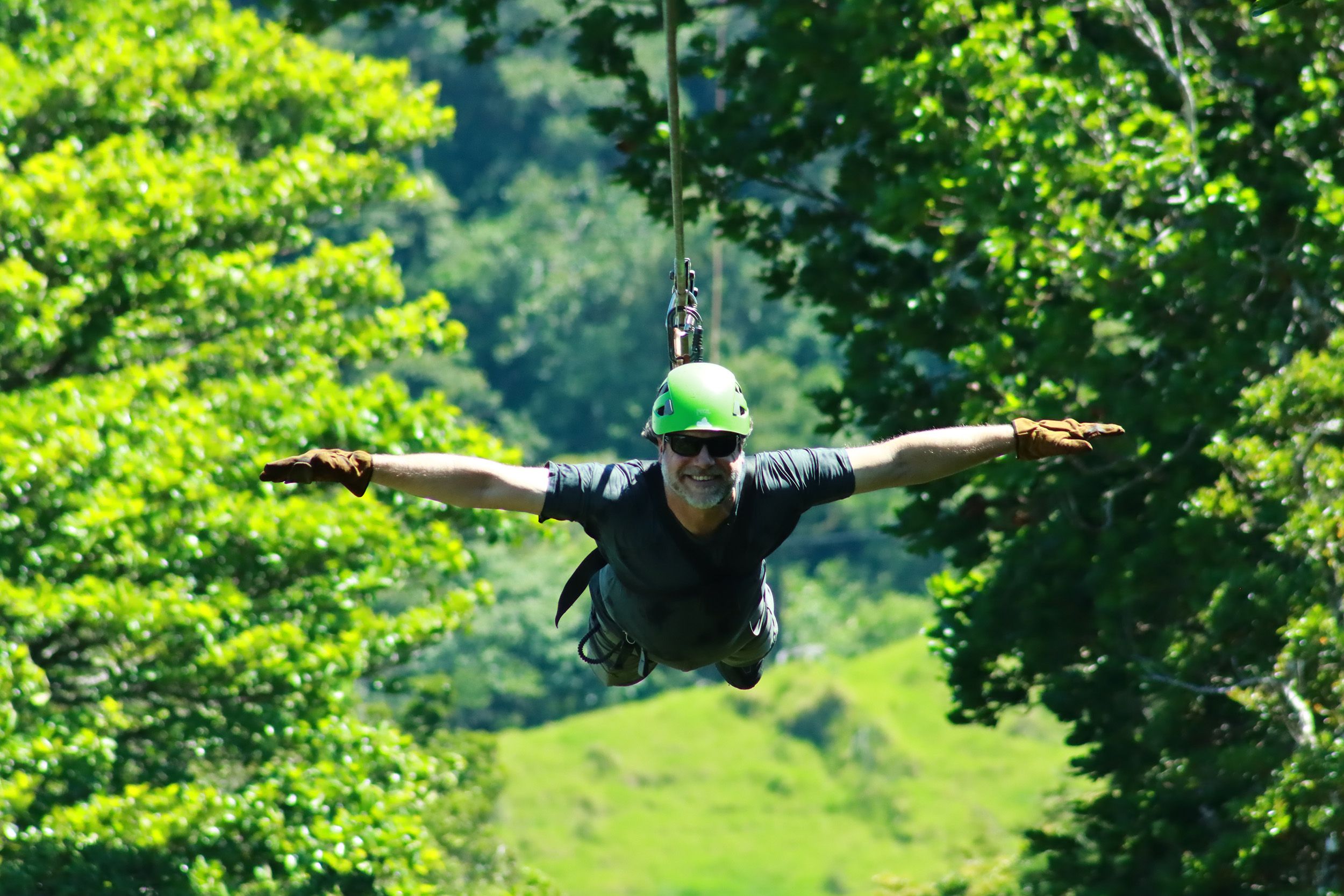 Tourist enjoying a thrilling Superman zipline ride through the lush cloud forest of Monteverde, Costa Rica.