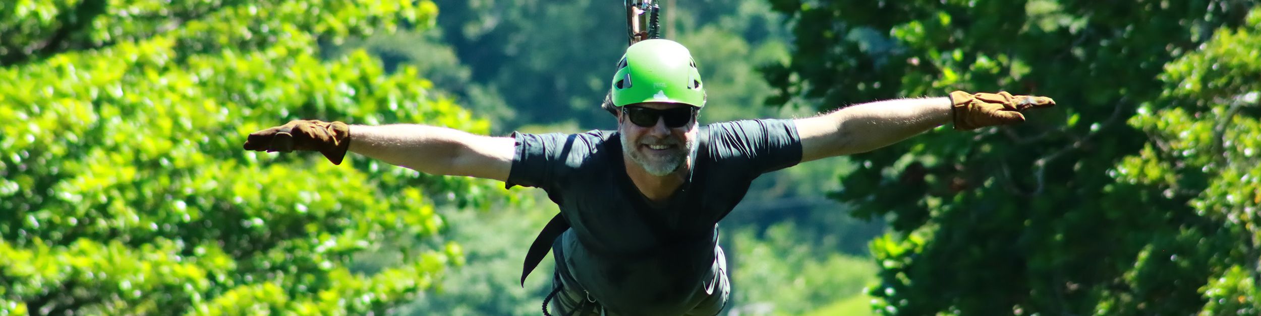 Turista che si gode un'emozionante avventura sulla zipline Superman attraverso la lussureggiante foresta nebulosa di Monteverde, Costa Rica.