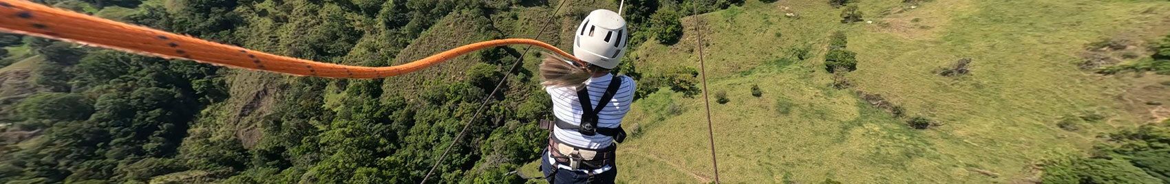 Persoon geniet van de Tarzan Swing in Monteverde Extremo Park, zwaaiend over weelderige groene landschappen.