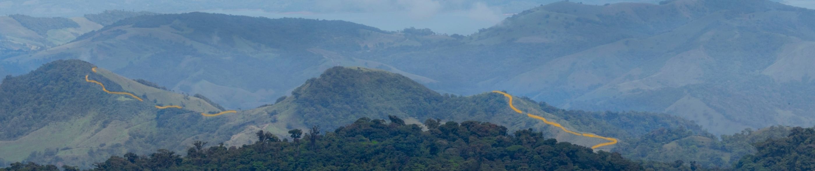 Uitzicht op de bergen van Monteverde, Costa Rica, met een blauwe lucht en witte wolken in prachtig contrast.