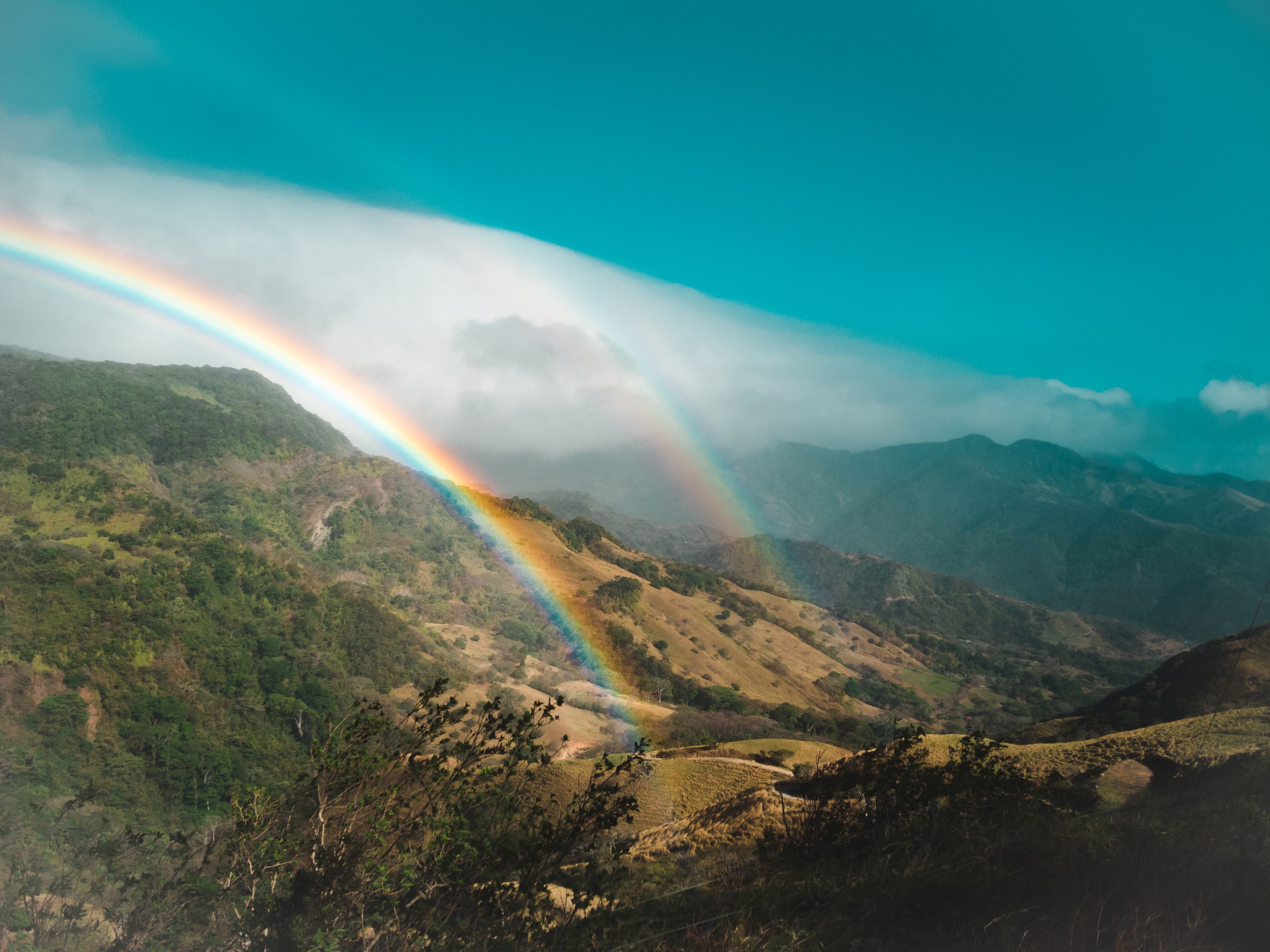 A double rainbow shining over the mountainous landscapes of Monteverde, Costa Rica.